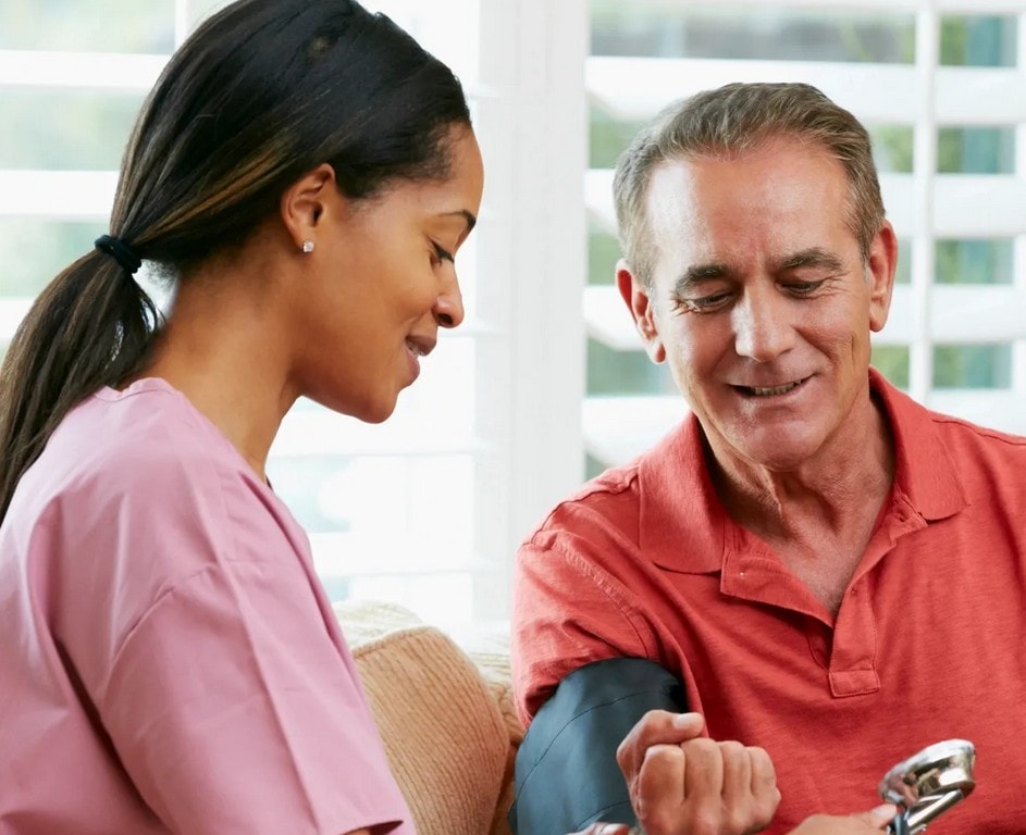 Nurse checking patient blood pressure during consultation